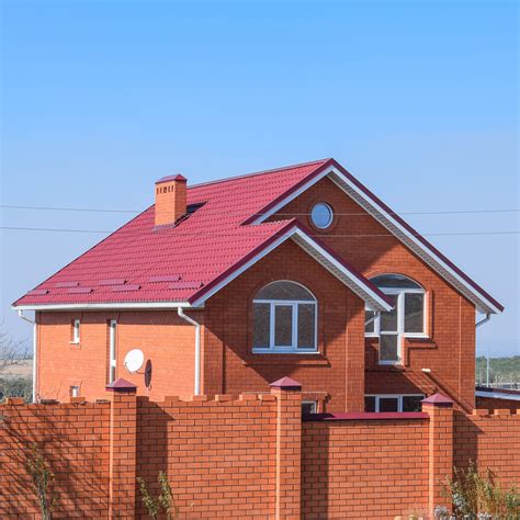 brick house with a metal roof|matching brick and roof colors.